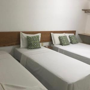 Duas camas num quarto com paredes brancas em Bahia Bonita Flat em Itacaré