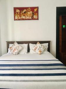 a bed with blue and white pillows on it at River Side Guest house in Maskeliya