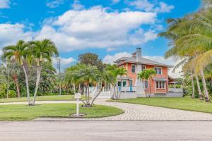 une maison avec des palmiers devant elle dans l'établissement Palm City Home with Decks and Florida Room - Near Golf, à Stuart