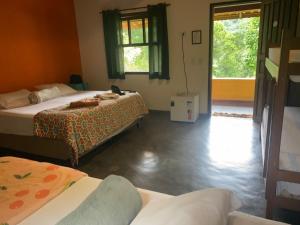 a room with two beds and a window at Pousada Rancho da Serra PETAR in Iporanga