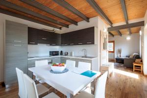 a kitchen and dining room with a white table and chairs at REVO Apartments - Cà Berti in Teglio