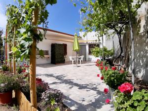 a patio with flowers and a table and an umbrella at Il Melograno in Badesi