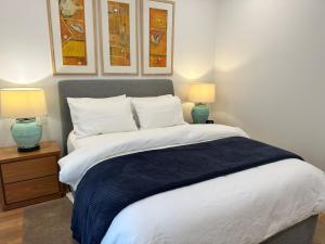 1 dormitorio con 1 cama grande y 2 lámparas en The Getaway - Galston, en Galston