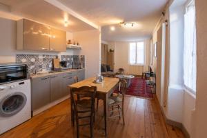 - une cuisine avec une table et un lave-linge dans l'établissement Maison du pêcheur 1 / Duplex chaleureux, à Argenton-sur-Creuse