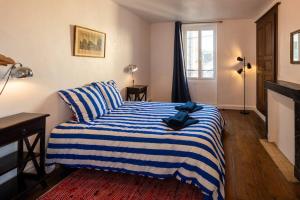 - une chambre dotée d'un lit avec une couverture rayée bleue et blanche dans l'établissement Maison du pêcheur 1 / Duplex chaleureux, à Argenton-sur-Creuse