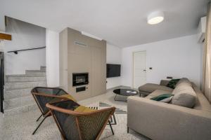 een woonkamer met een bank en stoelen bij Villa Cangarela 117 in Višnjan
