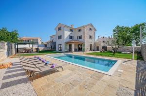 een villa met een zwembad en een huis bij Villa Cangarela 117 in Višnjan