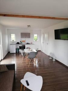 ein Wohnzimmer mit einem Tisch und Stühlen sowie eine Küche in der Unterkunft Ferienwohnung am Stettiner Haff in Mönkebude