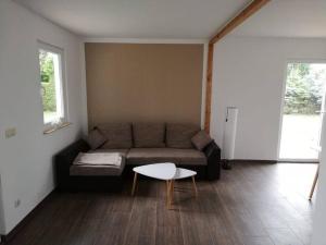 ein Wohnzimmer mit einem Sofa und einem Tisch in der Unterkunft Ferienwohnung am Stettiner Haff in Mönkebude
