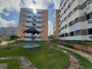 a large building with an umbrella in the grass at Apartamento confortável e sofisticado em Aracaju in Aracaju