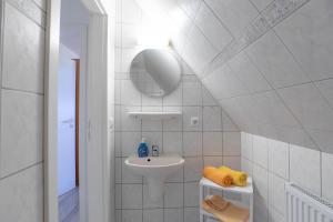 een witte badkamer met een wastafel en een spiegel bij Ferienhaus Frisia - Wohnung 2 in Nordstrand