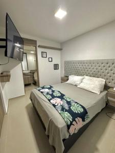 Schlafzimmer mit einem Bett und einem Flachbild-TV in der Unterkunft Bello apt, cerca al mar in Cartagena de Indias