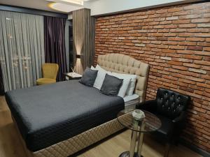 a bedroom with a bed and a brick wall at Nomad Hub Istanbul Residence in Istanbul