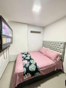 Zimmer mit einem Bett und einem Flachbild-TV in der Unterkunft Bello apt, cerca al mar in Cartagena de Indias