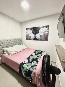 ein kleines Schlafzimmer mit einem Bett mit einer rosa Decke in der Unterkunft Bello apt, cerca al mar in Cartagena de Indias