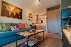 - un salon avec un canapé bleu et une table dans l'établissement Alpine Home Sierra Nevada, à Sierra Nevada