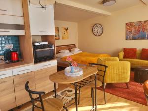 uma cozinha e uma sala de estar com mesa e cadeiras em Secret Garden Apartman em Budapeste