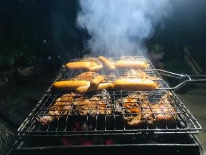 Ein Haufen Hot Dogs, die auf einem Grill kochen. in der Unterkunft River Side Guest house in Maskeliya