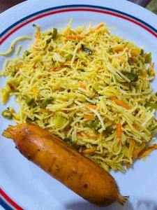 a plate of food with cabbage and carrots at River Side Guest house in Maskeliya