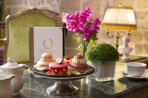 une table avec un plateau de pâtisseries sur une table dans l'établissement Académie Hôtel Saint Germain, à Paris