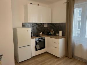 eine Küche mit einem weißen Kühlschrank und einem Herd in der Unterkunft Wohnung 1210 in Wien