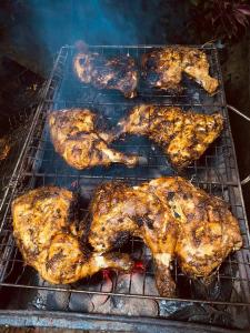 a group of chickens cooking on a grill at River Side Guest house in Maskeliya