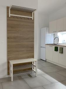 a white kitchen with a bench and a refrigerator at The View 22 in Cerklje na Gorenjskem