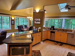 a large kitchen with a large island in a room at Woodshores Retreat - cozy retreat, hot tub, Lk MI in Coloma