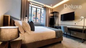 a bedroom with a bed and a desk and a television at Hotel Vitruvio in Milan