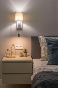 a bedside table with a lamp next to a bed at Luxurious & Spacious Central Residence with Balcony in Budapest