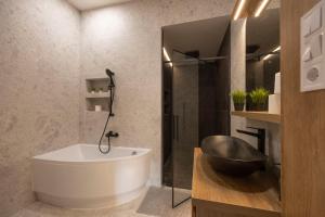 a bathroom with a bath tub and a sink at Luxurious & Spacious Central Residence with Balcony in Budapest