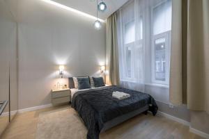 a bedroom with a bed and a large window at Luxurious & Spacious Central Residence with Balcony in Budapest