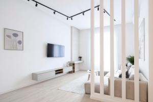 a white room with a bed and a tv at Luxurious & Spacious Central Residence with Balcony in Budapest