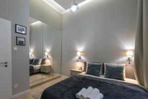 a bedroom with a large bed with two mirrors at Luxurious & Spacious Central Residence with Balcony in Budapest