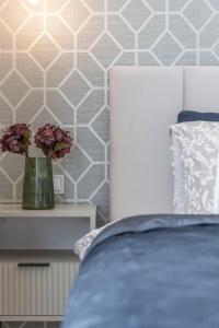 a bedroom with a bed and a vase with flowers at Luxurious & Spacious Central Residence with Balcony in Budapest
