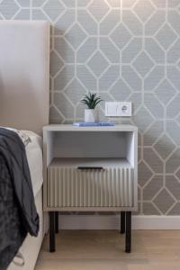 a bedside table with a plant on it in a bedroom at Luxurious & Spacious Central Residence with Balcony in Budapest