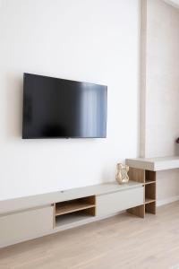 a living room with a tv on a white wall at Luxurious & Spacious Central Residence with Balcony in Budapest