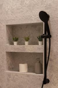 a black microphone on a shelf with potted plants at Luxurious & Spacious Central Residence with Balcony in Budapest