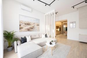 a white living room with a couch and a table at Luxurious & Spacious Central Residence with Balcony in Budapest