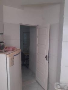 a kitchen with a white door and a refrigerator at Joia Centro Manaus - Apartamento in Manaus
