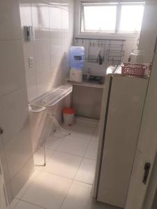 a small white kitchen with a sink and a window at Joia Centro Manaus - Apartamento in Manaus