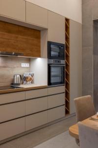 a kitchen with white cabinets and a microwave at Luxurious & Spacious Central Residence with Balcony in Budapest