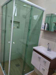a bathroom with a glass shower and a sink at Joia Centro Manaus - Apartamento in Manaus