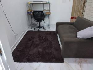 a living room with a couch and a desk at Joia Centro Manaus - Apartamento in Manaus