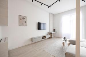 a white living room with a couch and a tv at Luxurious & Spacious Central Residence with Balcony in Budapest