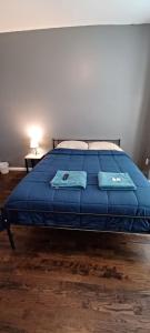 a bed in a room with a blue blanket on it at Willoughby in Newark