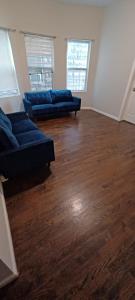 a living room with two blue couches and wood floors at Willoughby in Newark