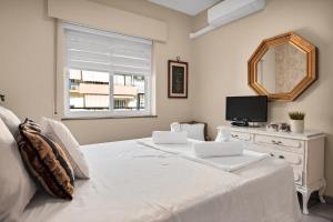 Schlafzimmer mit einem weißen Bett, einem Spiegel und einer Kommode in der Unterkunft Ubicación y confort en el centro de Marbella - RICARDO SORIANO 33 38 in Marbella