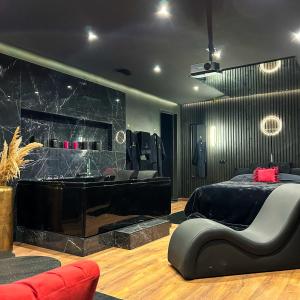 a bedroom with a black bed and a piano at BlackRoom Suite de Luxe 50 Nuances de grey in Le Havre