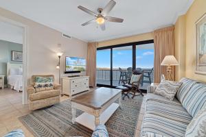 a living room with a couch and a tv at Grand Pointe Unit 303 in Orange Beach